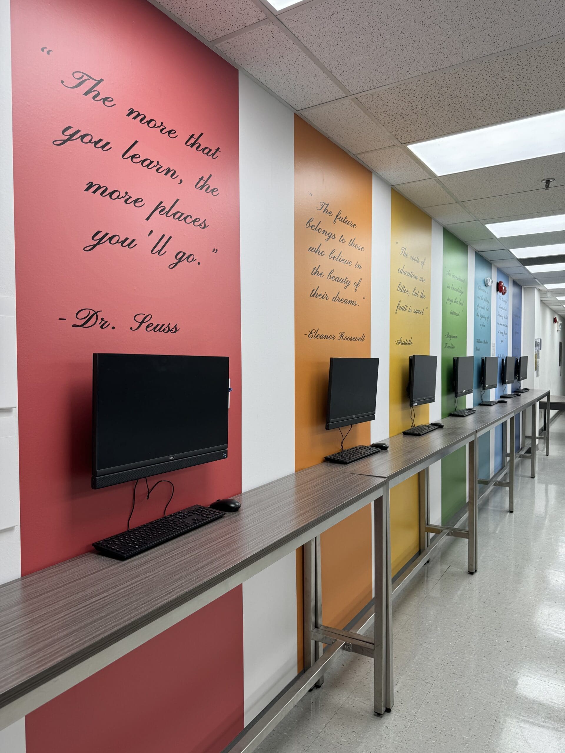 Ace Acumen Heights learning corridor with computer stations and quote walls